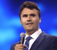 Charlie Kirk, de microfone na mão, fala numa conferência