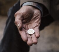 mendigo de mão estendida segura uma moeda