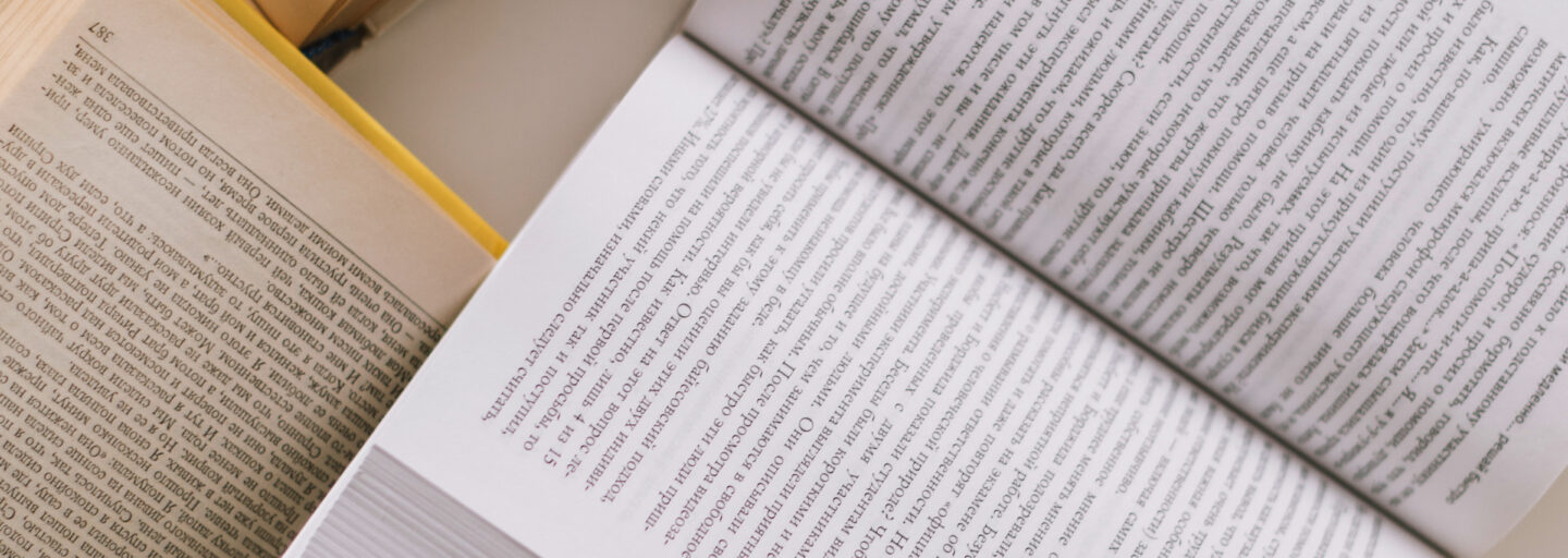 vários livros abertos, dispersos, sobre uma mesa