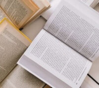 vários livros abertos, dispersos, sobre uma mesa