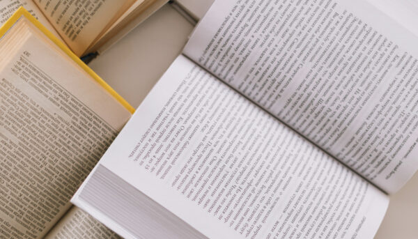 vários livros abertos, dispersos, sobre uma mesa