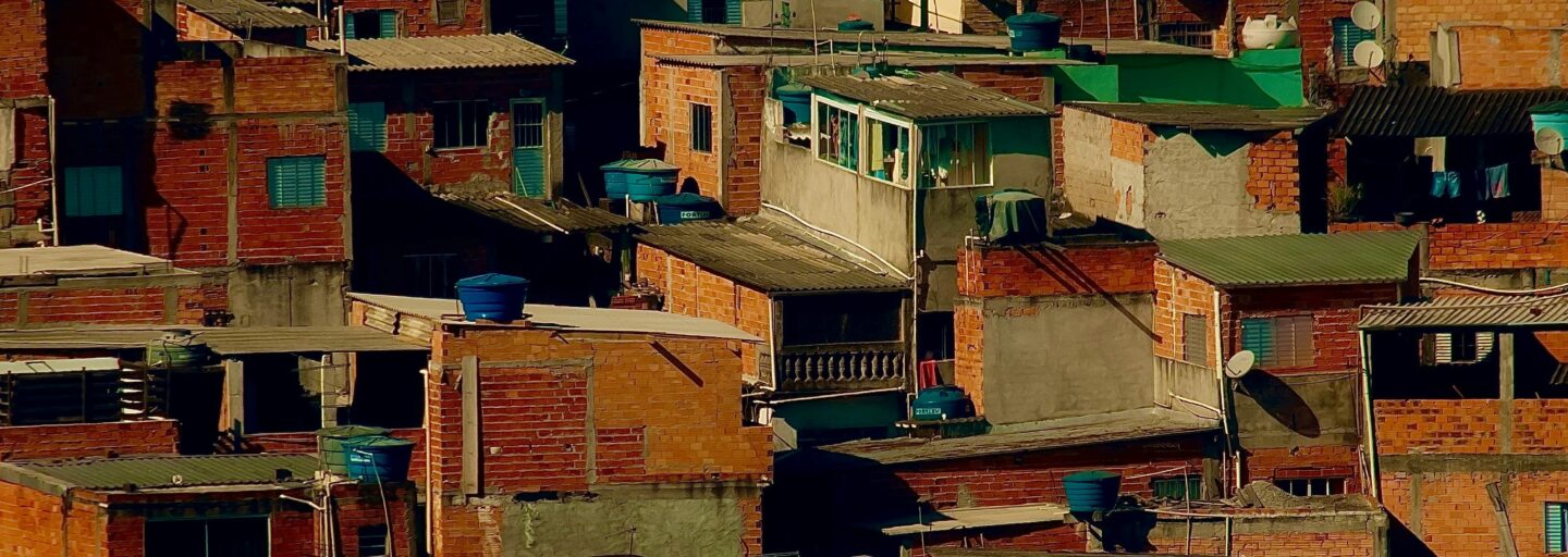 várias casas em tijolo, desordenadas, assentes numa colina
