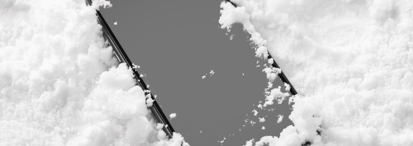telemóvel sobre a neve, com esta a cobrir levemente as extremidades