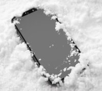 telemóvel sobre a neve, com esta a cobrir levemente as extremidades