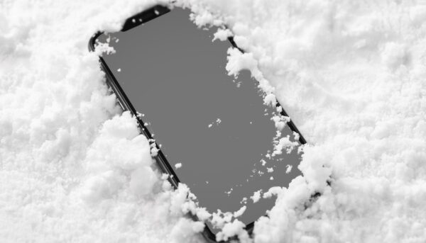 telemóvel sobre a neve, com esta a cobrir levemente as extremidades