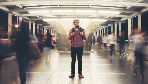 Handsome bearded man with backpack standing on the street traveling at night.